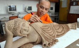 Delicate work: Ven Hou Heng doing a final touch-up of the sleeping Buddha statue made of incense which is one of the highlights on display for Penang Wesak Celebration Day