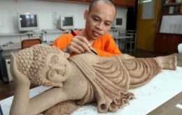 Delicate work: Ven Hou Heng doing a final touch-up of the sleeping Buddha statue made of incense which is one of the highlights on display for Penang Wesak Celebration Day