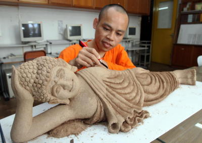 Delicate work: Ven Hou Heng doing a final touch-up of the sleeping Buddha statue made of incense which is one of the highlights on display for Penang Wesak Celebration Day